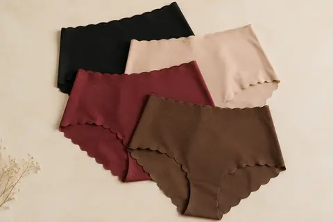 Lot de quatre shortys taille haute aux finitions ondulées, présentés à plat sur un fond crème