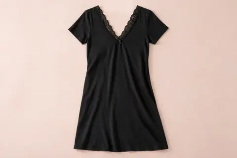 Chemise de nuit noire à manches courtes avec décolleté en V orné de dentelle, présentée sur fond crème.