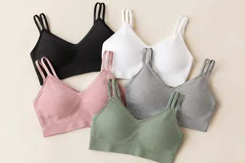Cinq brassières camisole aux coussinets amovibles, présentées dans leurs coloris noir, blanc, gris, rose et vert.