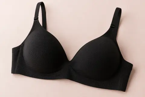 Soutien-gorge noir sans armatures à bonnets rembourrés, posé sur un fond crème.