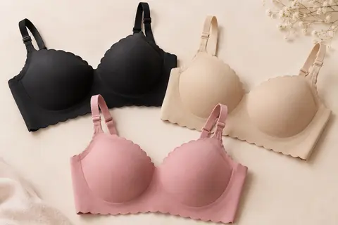 Trois soutiens-gorge sans armatures noirs, beiges et roses, présentés sur un fond crème doux.