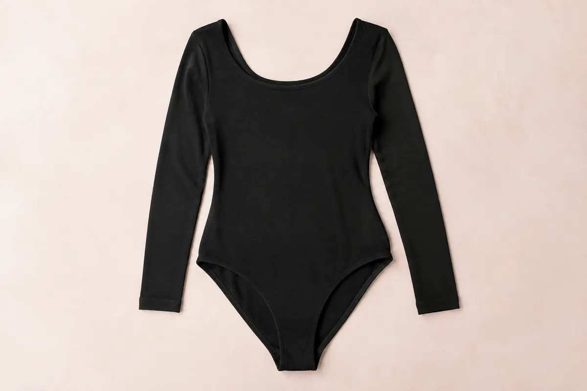 Body noir à manches longues en coton extensible, présenté à plat sur un fond crème doux.