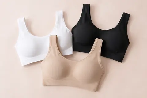 Trois brassières Risalti sans armatures en microfibre, blanches, noires et naturelles, présentées sur fond crème.